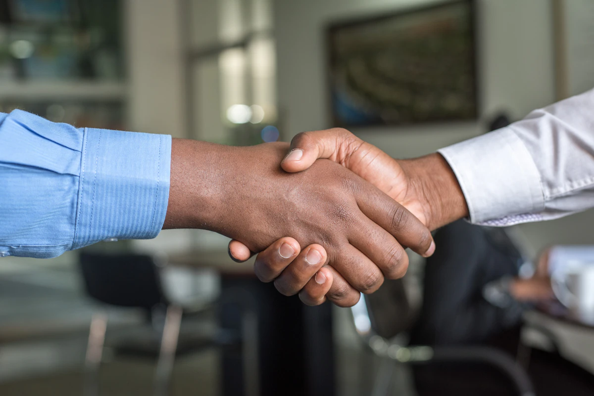 Professional handshake representing the choice between public adjuster and insurance adjuster